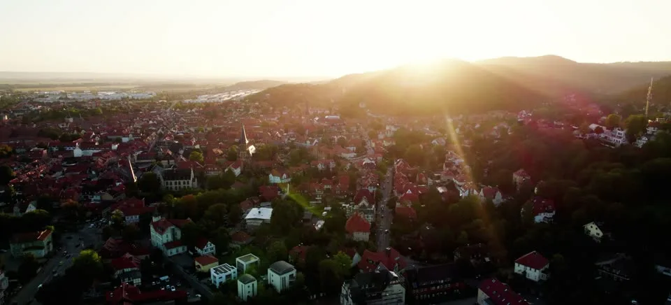 Luftaufnahme von Wernigerode im Abendlicht, dahinter die Berge des Harzes